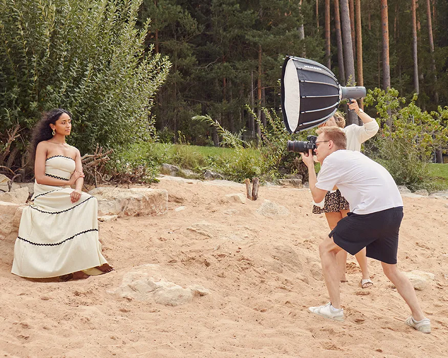 Fotoshooting draußen in natürlicher Umgebung am Strand mit Model und großer Softbox